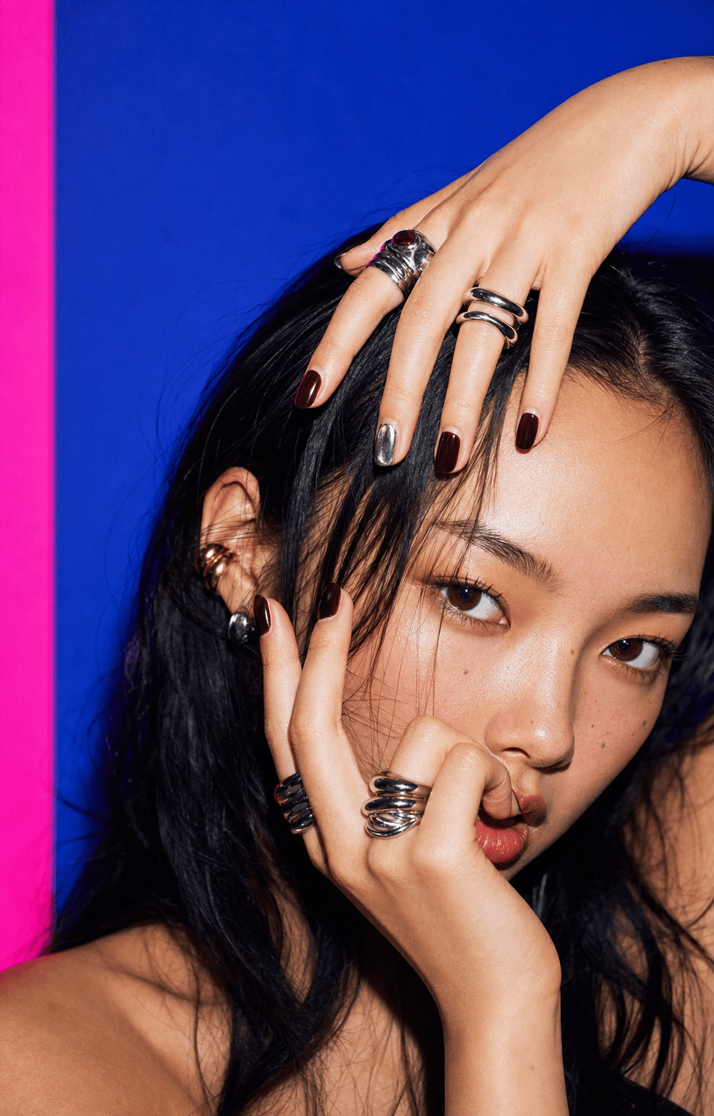 Cobalt editorial portrait with jewelry-forward styling and manicured hand energy