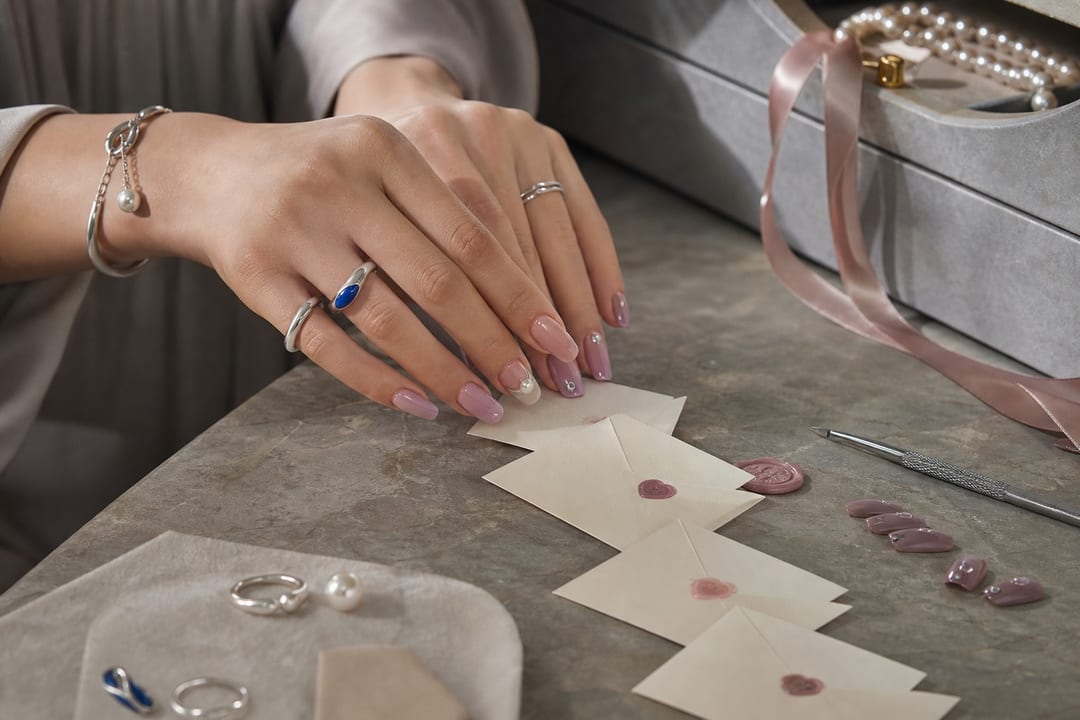 Valentine’s Day nails in pink press-on designs laid like tiny love letters with careful, clean styling tools
