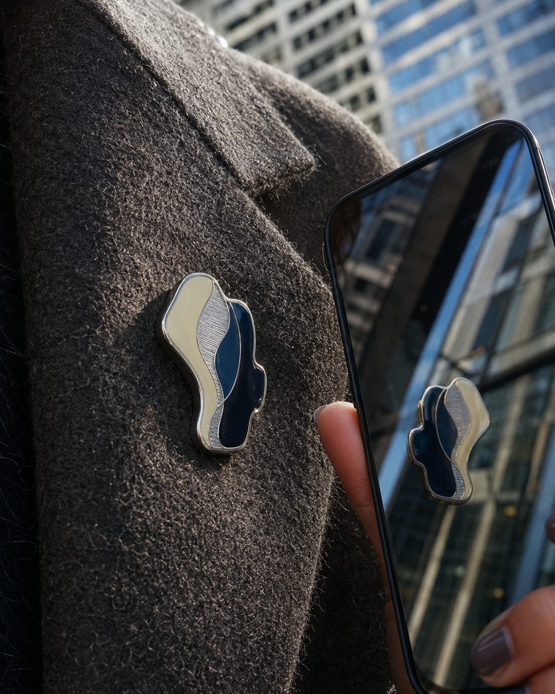 merch culture semiotics — close-up of a badge reflected in a phone screen