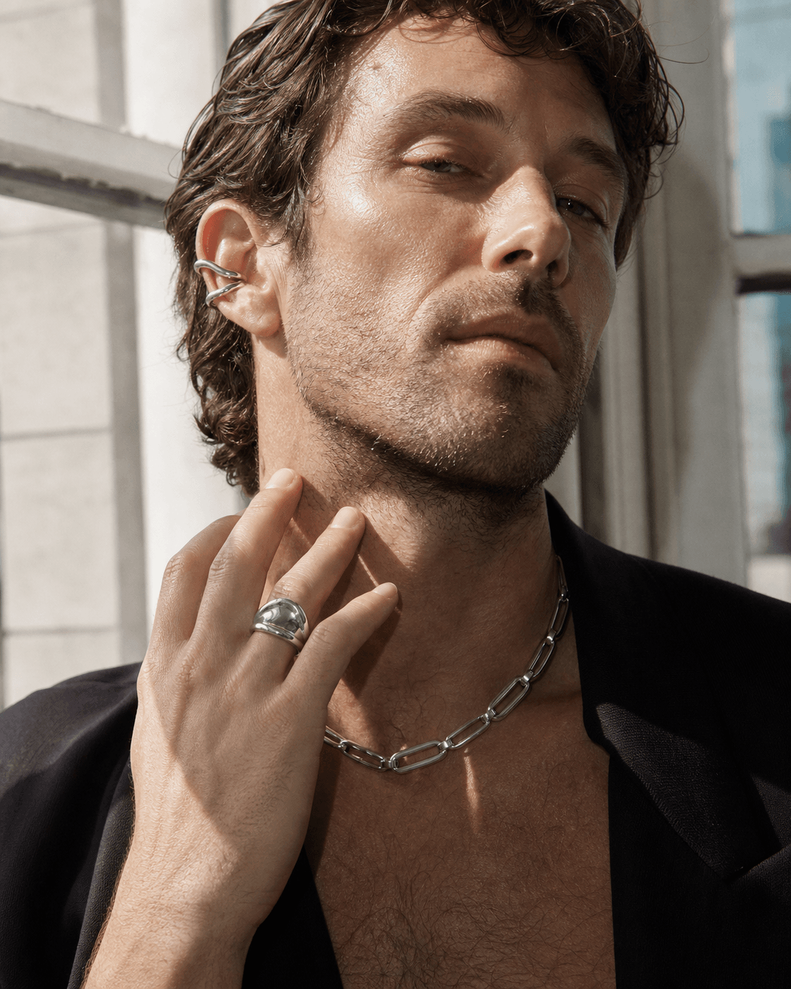 Editorial ear cuff styling in daylight with sculptural jewelry focus